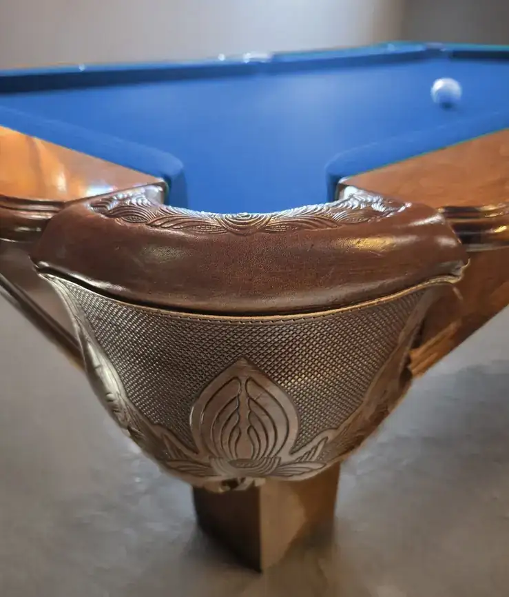 An engraved leather pocket on an antique pool table