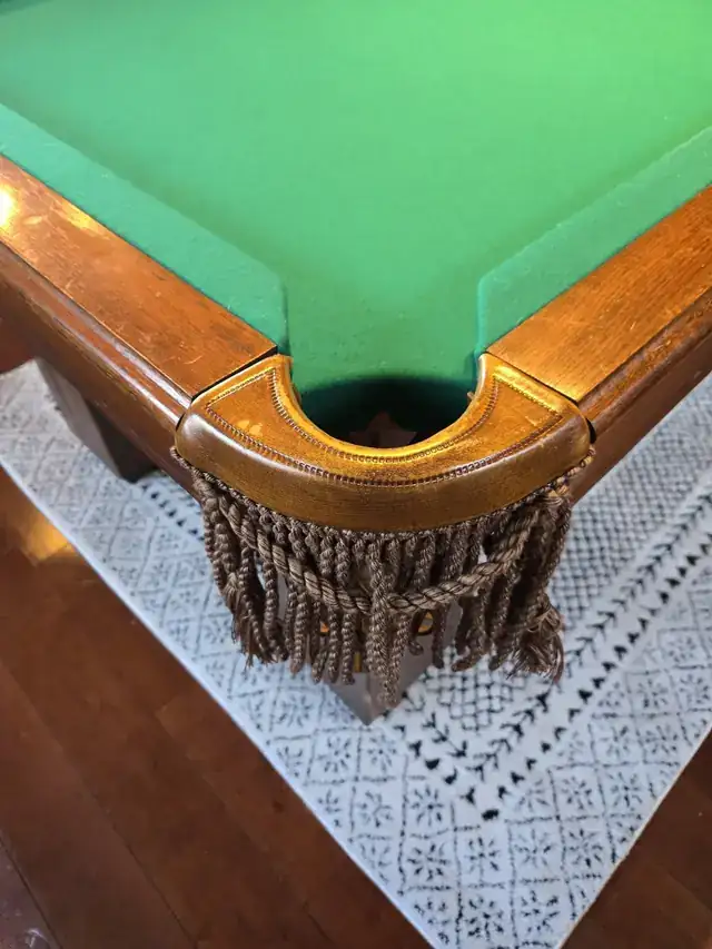 A fringed leather pocket on a pool table